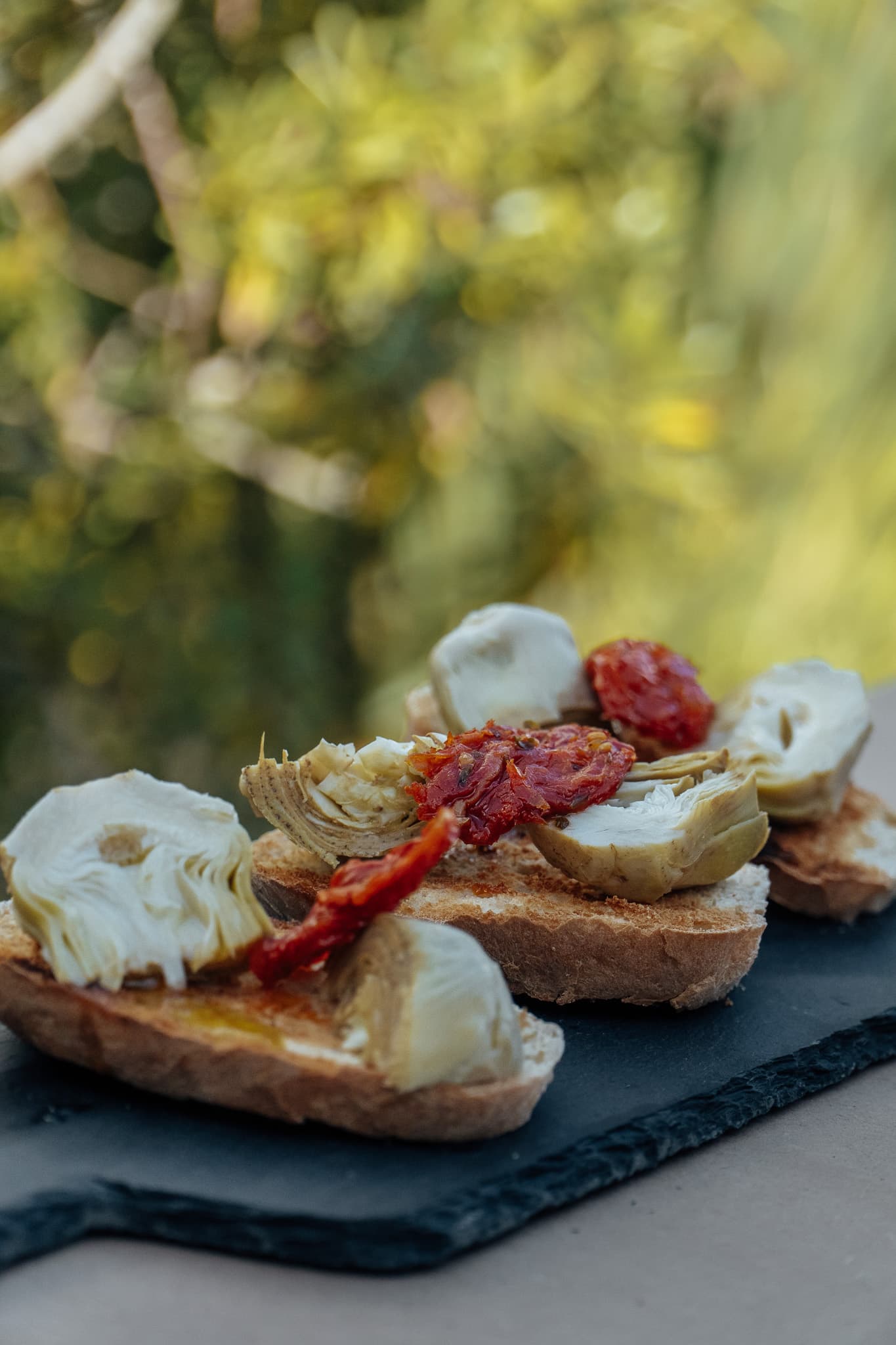 Bruschettas con alcauciles y tomates secos preparadas con productos Meridiano